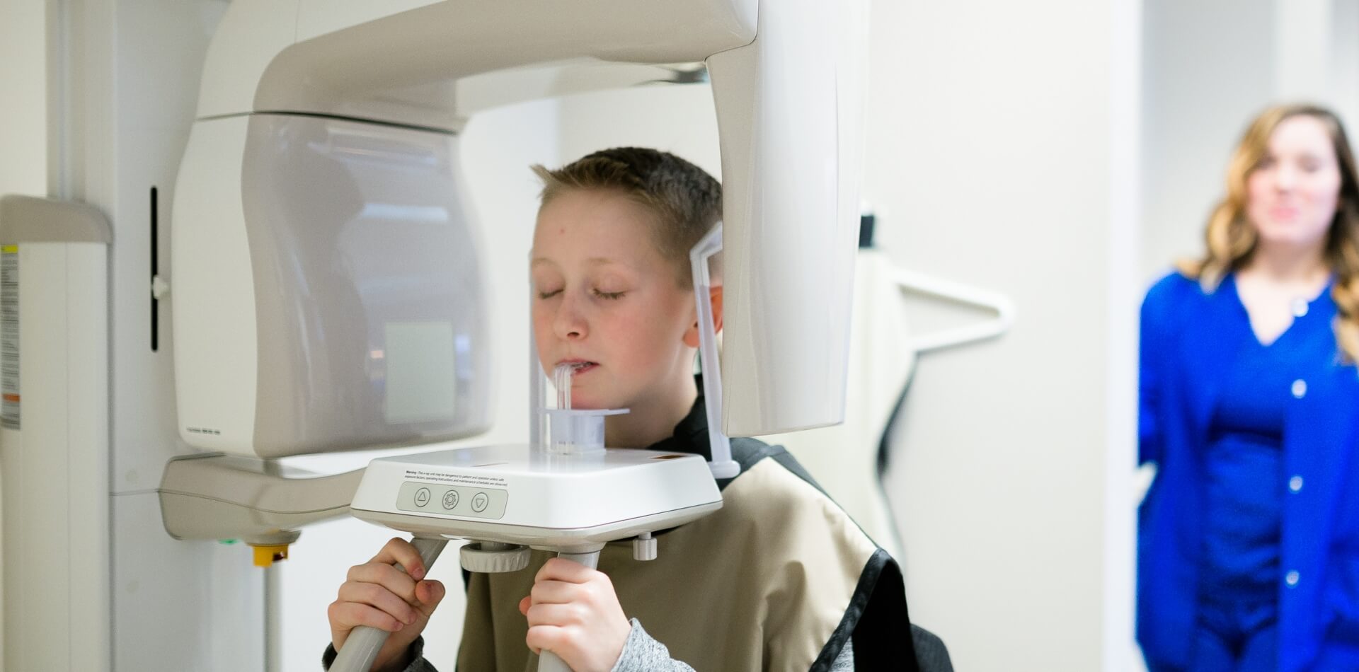 A patient using an X-ray machine at a dental clinic
